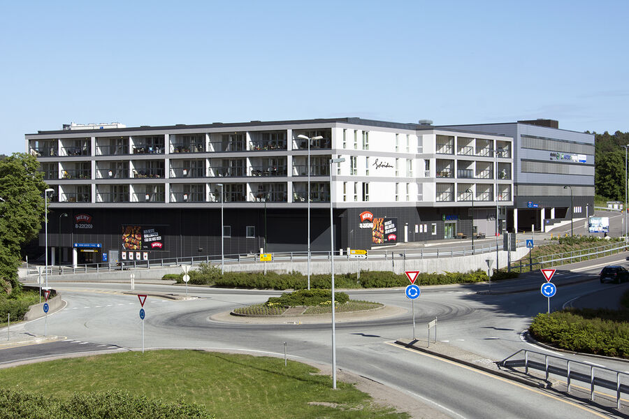 Bygning med boliger og butikker i Rona