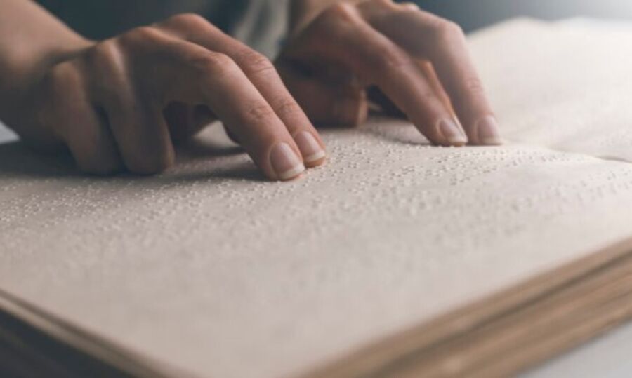 Bilde: tibi.no bok i punktskrift, hender som leser i boka